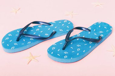 Plaj aksesuarları. Renkli arka planda parmak arası terlik ve denizyıldızı. Üst görünüm Kopyalama alanı ile modelle.