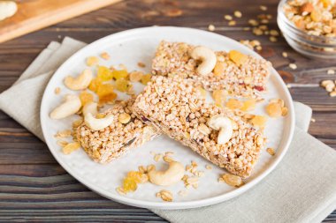 Arka planda çeşitli granola barlar var. Mısır gevreği gofretleri. Yulaf, fındık ve böğürtlenli kahvaltı barları, yakın çekim. Süper yiyecek konsepti.