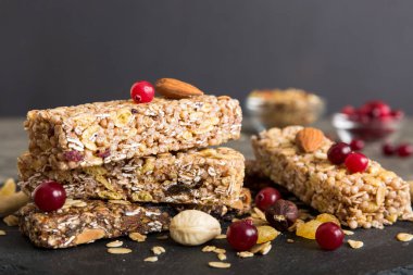 Arka planda çeşitli granola barlar var. Mısır gevreği gofretleri. Yulaf, fındık ve böğürtlenli kahvaltı barları, yakın çekim. Süper yiyecek konsepti.