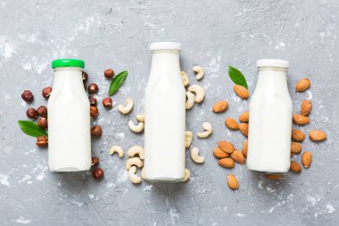 Masa arkasında çeşitli vejetaryen süt bademi, kaju fıstığı seti ya da koleksiyonu. Vejetaryen bitkisi sütü ve malzemeleri, üst görünüm.