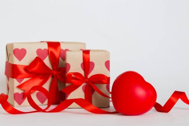 gift box with red bow and red heart on colored background. Perspective view. Flat lay.