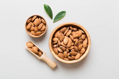 Fresh healthy Almond in bowl on colored table background. Top view.