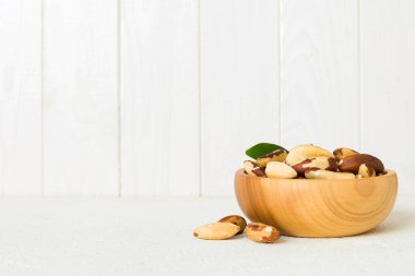Fresh healthy Brazil nuts in bowl on colored table background. Top view Healthy eating bertholletia concept. Super foods.