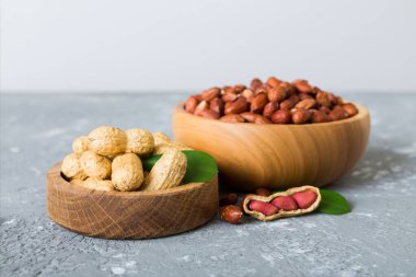 Fresh healthy peanuts in bowl on colored table background. Top view Healthy eating bertholletia concept. Super foods.