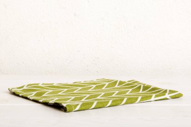top view with green kitchen napkin isolated on table background. Folded cloth for mockup with copy space, Flat lay. Minimal style.