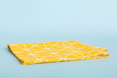 top view with yellow empty kitchen napkin isolated on table background. Folded cloth for mockup with copy space, Flat lay. Minimal style.