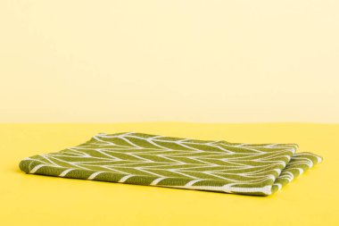 top view with green kitchen napkin isolated on table background. Folded cloth for mockup with copy space, Flat lay. Minimal style.