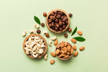 Renkli masadaki ahşap kasede fındık çeşitleri. Ceviz, fındık, ceviz, badem. Fındık Üst görünümü ile kopyalama alanını karıştır.