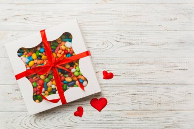 Valentine day composition: sweet candy, with gift boxes with bow and red felt hearts, photo template, background. Top View with copy space.