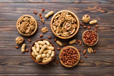 Ceviz çekirdeği yarım, ahşap bir kasede. Yakın plan, yukarıdan, renkli arkaplanda. Sağlıklı beslenme kavramı. Kopyalama alanı olan süper gıdalar.