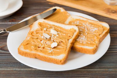 Fıstık ezmeli sandviç ya da arka planda kızarmış ekmek. Kahvaltı. Vejetaryen yemeği. Amerikan mutfağının üst görünümü kopyalama alanı.