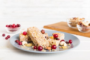 Arka planda çeşitli granola barlar var. Mısır gevreği gofretleri. Yulaf, fındık ve böğürtlenli kahvaltı barları, yakın çekim. Süper yiyecek konsepti.