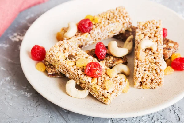 Various granola bars on table background. Cereal granola bars. Superfood breakfast bars with oats, nuts and berries, close up. Superfood concept.