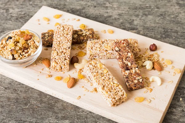 Various granola bars on table background. Cereal granola bars. Superfood breakfast bars with oats, nuts and berries, close up. Superfood concept.
