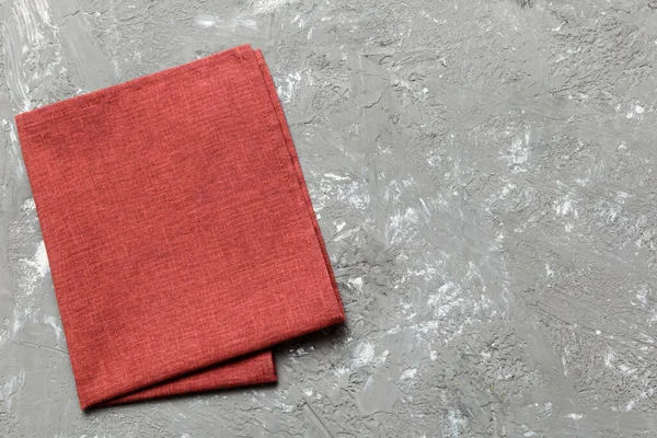 stock image top view with red empty kitchen napkin isolated on table background. Folded cloth for mockup with copy space, Flat lay. Minimal style.