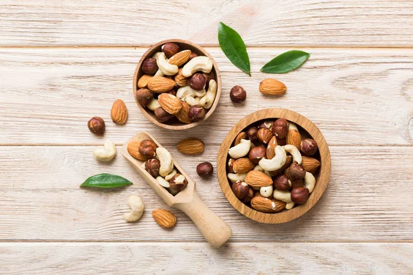 stock image Assortment of nuts in wooden bowl on colored table. Cashew, hazelnuts, walnuts, almonds. Mix of nuts Top view with copy space.