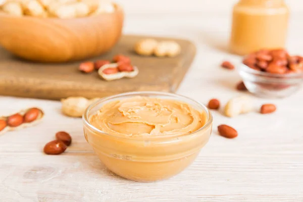 stock image Bowl of peanut butter and peanuts on table background. top view with copy space. Creamy peanut pasta in small bowl.