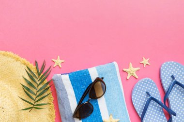 Yaz tatili konsepti düzdü. Hasır şapka plaj aksesuarları ve havlunun üstü. Mesaj için yer var. seyahat kavramı.