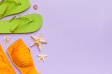 Kadın mayo ve plaj aksesuarları renkli arka plan yaz seyahati konseptine düz bir görünüm kazandırıyordu. Bikini mayo, hasır şapka ve deniz topuklu ayakkabı. Üst görünümü kopyala.