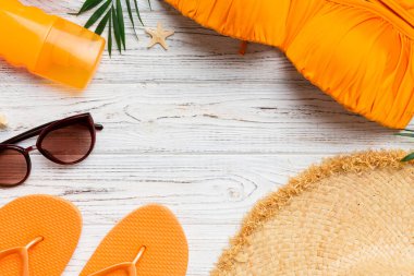 Kadın mayo ve plaj aksesuarları renkli arka plan yaz seyahati konseptine düz bir görünüm kazandırıyordu. Bikini mayo, hasır şapka ve deniz topuklu ayakkabı. Üst görünümü kopyala.