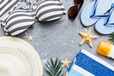 Kadın mayo ve plaj aksesuarları renkli arka plan yaz seyahati konseptine düz bir görünüm kazandırıyordu. Bikini mayo, hasır şapka ve deniz topuklu ayakkabı. Üst görünümü kopyala.