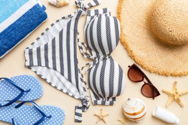 Kadın mayo ve plaj aksesuarları renkli arka plan yaz seyahati konseptine düz bir görünüm kazandırıyordu. Bikini mayo, hasır şapka ve deniz topuklu ayakkabı. Üst görünümü kopyala.