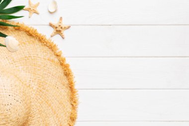 Summer holidays. Summer concept with straw hat and tropical leaf. Flat lay, top view, copy space.