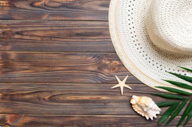 Summer holidays. Summer concept with straw hat and tropical leaf. Flat lay, top view, copy space.