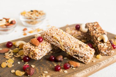 Arka planda çeşitli granola barlar var. Mısır gevreği gofretleri. Yulaf, fındık ve böğürtlenli kahvaltı barları, yakın çekim. Süper yiyecek konsepti.