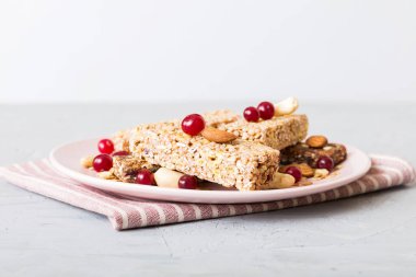 Arka planda çeşitli granola barlar var. Mısır gevreği gofretleri. Yulaf, fındık ve böğürtlenli kahvaltı barları, yakın çekim. Süper yiyecek konsepti.