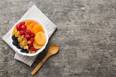 Masa arkasında farklı kurumuş meyveler olan bir kase, üst manzara. Kopyalama alanı olan sağlıklı yaşam biçimi.