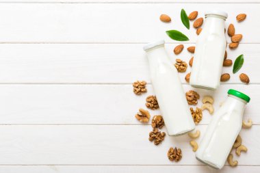 Masa arkasında çeşitli vejetaryen süt bademi, kaju fıstığı seti ya da koleksiyonu. Vejetaryen bitkisi sütü ve malzemeleri, üst görünüm.