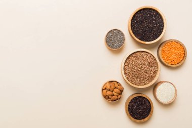 Smal Bowl 'da renkli arka planda çeşitli süper yiyecekler. Pirinç, chia, kinoa, mercimek, fındık, susam tohumu, badem gibi süper yiyecekler. üst görünüm kopyalama alanı.