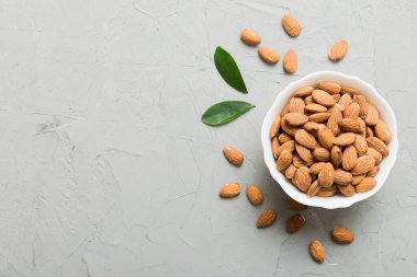Fresh healthy Almond in bowl on colored table background. Top view.