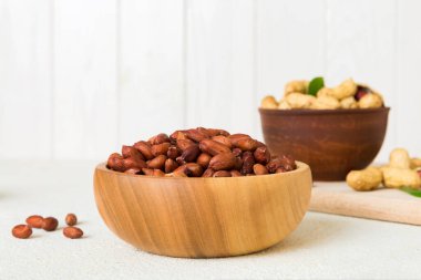 Fresh healthy peanuts in bowl on colored table background. Top view Healthy eating bertholletia concept. Super foods.
