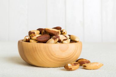 Fresh healthy Brazil nuts in bowl on colored table background. Top view Healthy eating bertholletia concept. Super foods.