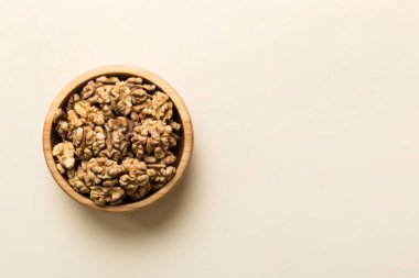 Fresh healthy walnuts in bowl on colored table background. Top view Healthy eating bertholletia concept. Super foods.