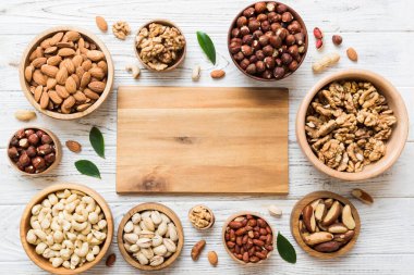 mixed nuts in wooden bowl. Mix of various nuts on colored background. pistachios, cashews, walnuts, hazelnuts, peanuts and brazil nuts.