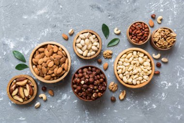 mixed nuts in wooden bowl. Mix of various nuts on colored background. pistachios, cashews, walnuts, hazelnuts, peanuts and brazil nuts.