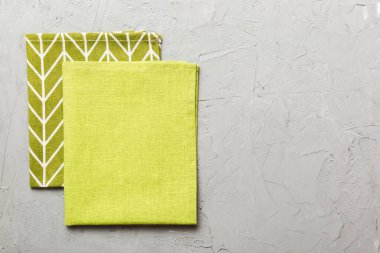 top view with green kitchen napkin isolated on table background. Folded cloth for mockup with copy space, Flat lay. Minimal style.