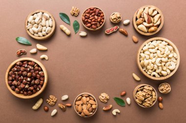 mixed nuts in wooden bowl. Mix of various nuts on colored background. pistachios, cashews, walnuts, hazelnuts, peanuts and brazil nuts.