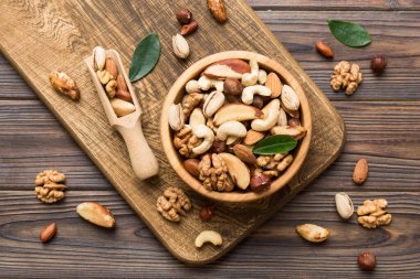 mixed nuts in bowl. Mix of various nuts on colored background. pistachios, cashews, walnuts, hazelnuts, peanuts and brazil nuts.