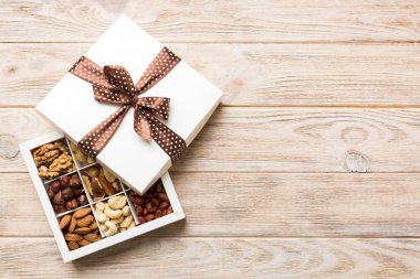 Various varieties of nuts lying in paper box on table background. Top view. Healthy food. Close up, copy space, top view, flat lay. Walnut, pistachios, almonds, hazelnuts and cashews.