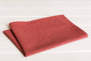 top view with red empty kitchen napkin isolated on table background. Folded cloth for mockup with copy space, Flat lay. Minimal style.