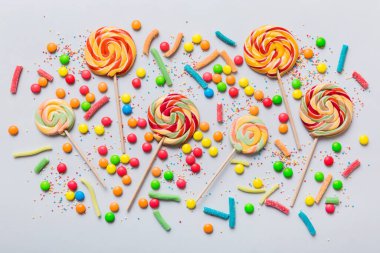 Lezzetli İştah açıcı Parti Aksesuarları Mutlu Yıllar Tatlı. Renkli arkaplanda farklı tipte şekerler, kopyalama alanı. Renkli doğum günü partisi geçmişi.