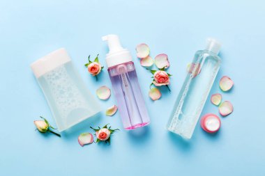 Fancy healthcare bottles for serum, micellar, tonic, toner, lotion, water and cream with rose flower. Natural oranic spa cosmetics concept. Mockup, template, Top view. clipart
