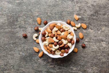 Renkli masadaki ahşap kasede fındık çeşitleri. Ceviz, fındık, ceviz, badem. Fındık Üst görünümü ile kopyalama alanını karıştır.