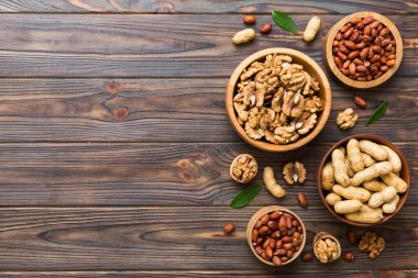 Ceviz çekirdeği yarım, ahşap bir kasede. Yakın plan, yukarıdan, renkli arkaplanda. Sağlıklı beslenme kavramı. Kopyalama alanı olan süper gıdalar.