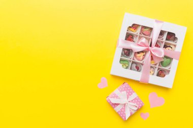 Valentine day composition: sweet candy, with gift boxes with bow and red felt hearts, photo template, background. Top View with copy space.