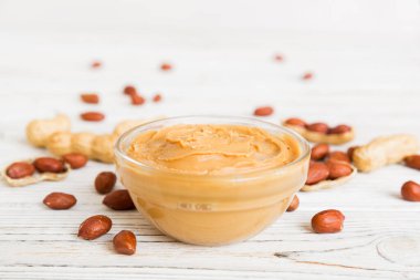 Arka planda bir kase fıstık ezmesi ve fıstık. Kopyalama alanı olan üst görünüm. Küçük kasede kremalı fıstıklı makarna.